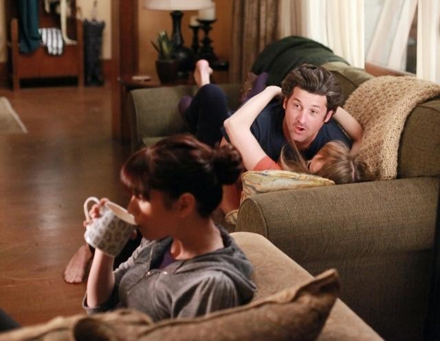Derek et Meredith sur leur canapé pendant que Lexie boit une infusion