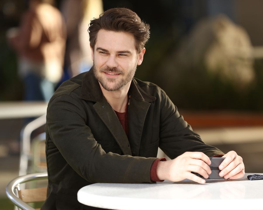 Jack (Grey Damon) assis à une table