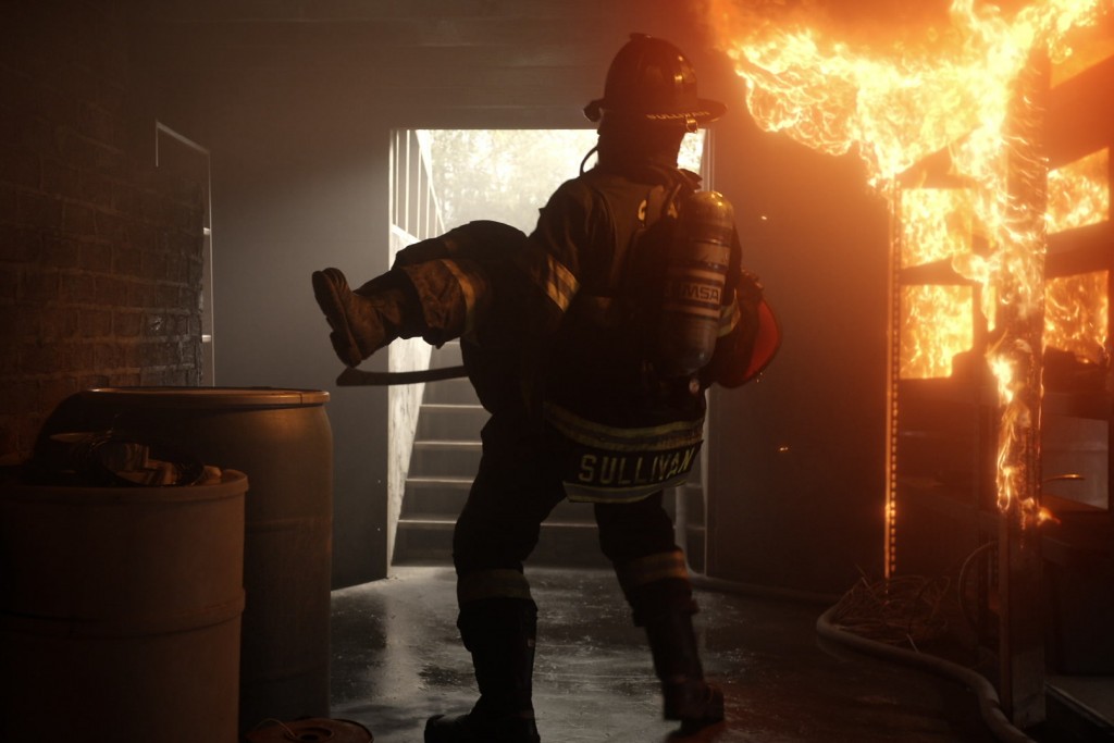 Robert Sullivan (Boris Kodjoe) porte un camarade dans un bâtiment en feu