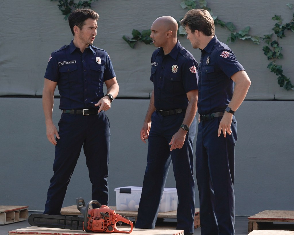 Travis Montgomery (Jay Hayden) discute avec deux pompiers